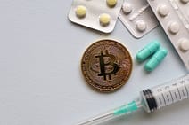 pexels photo 5435971 Image of a Bitcoin coin surrounded by pills and a syringe, symbolizing healthcare and finance.