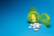 pexels photo 29205871 Image of a green pill bottle with white tablets scattered on a blue background, symbolizing healthcare and medication.