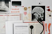 pexels photo 7723389 7723389 Overhead view of medical research equipment and study materials including books, x-rays, and stethoscope.